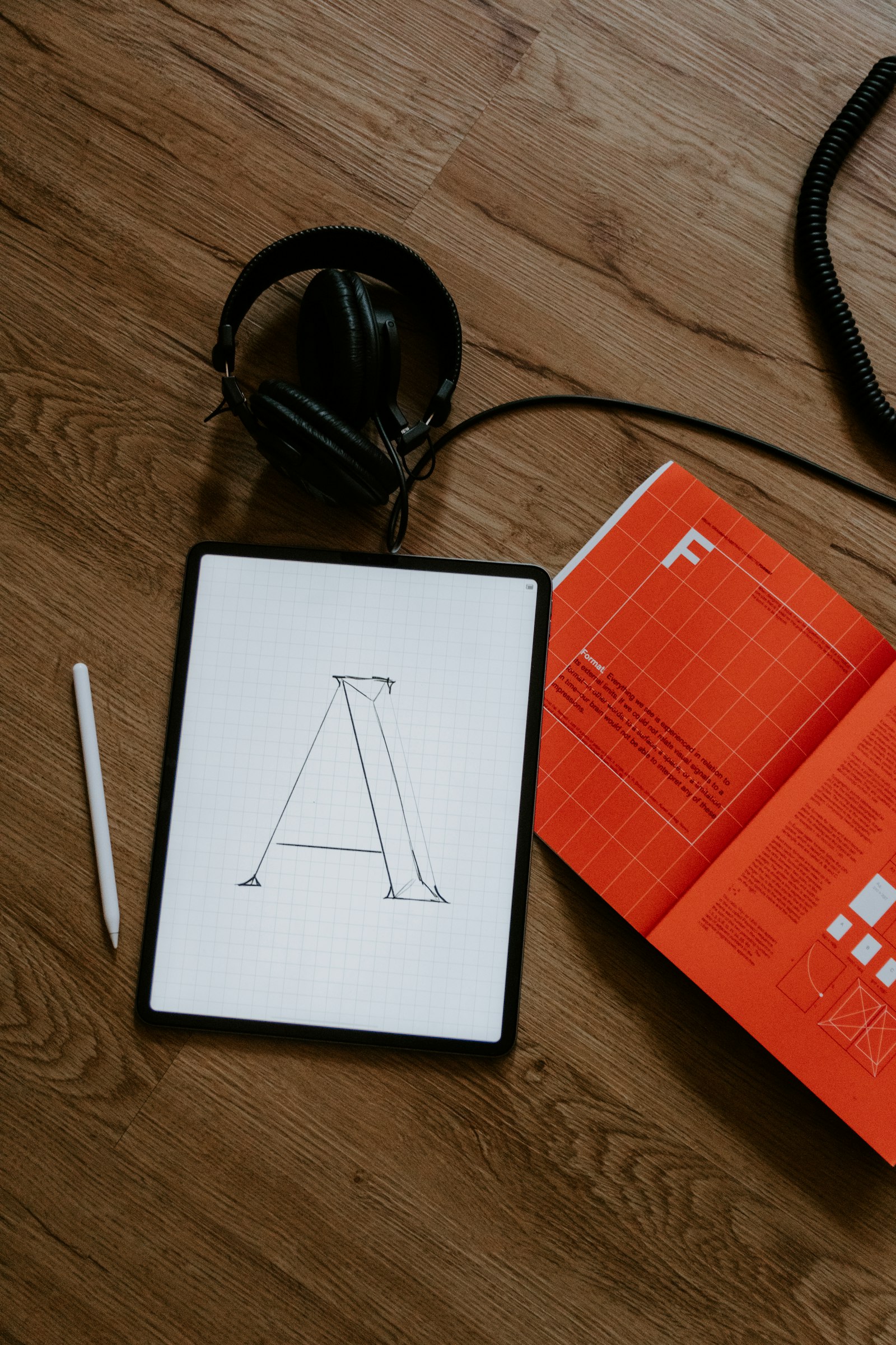 Creative portfolio example — typography sketch on tablet next to an editorial magazine spread